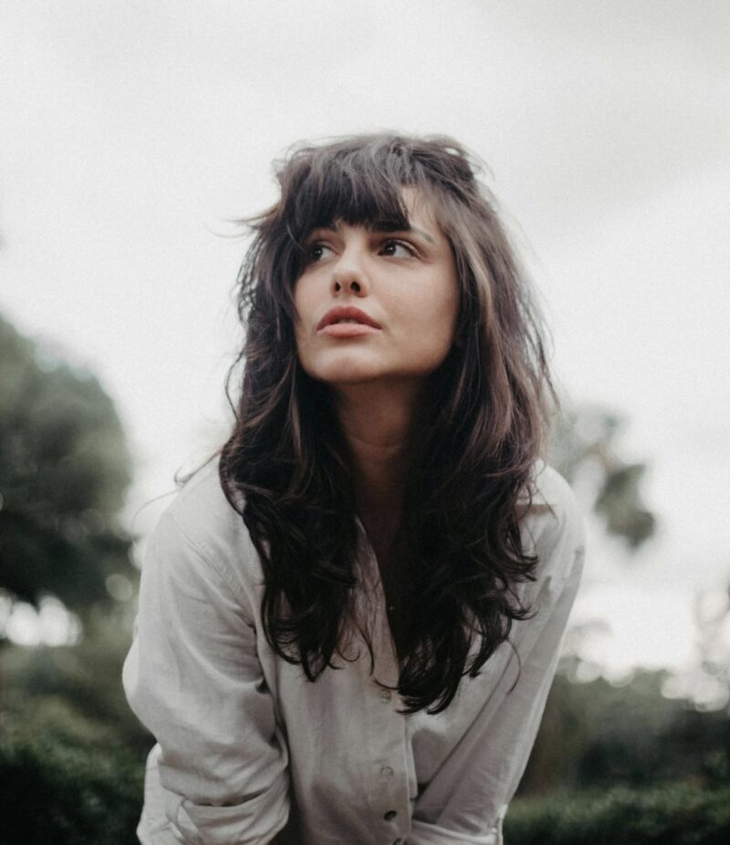 A woman with long hair and see-through bangs. A natural hairstyle designed with facial balance in mind.