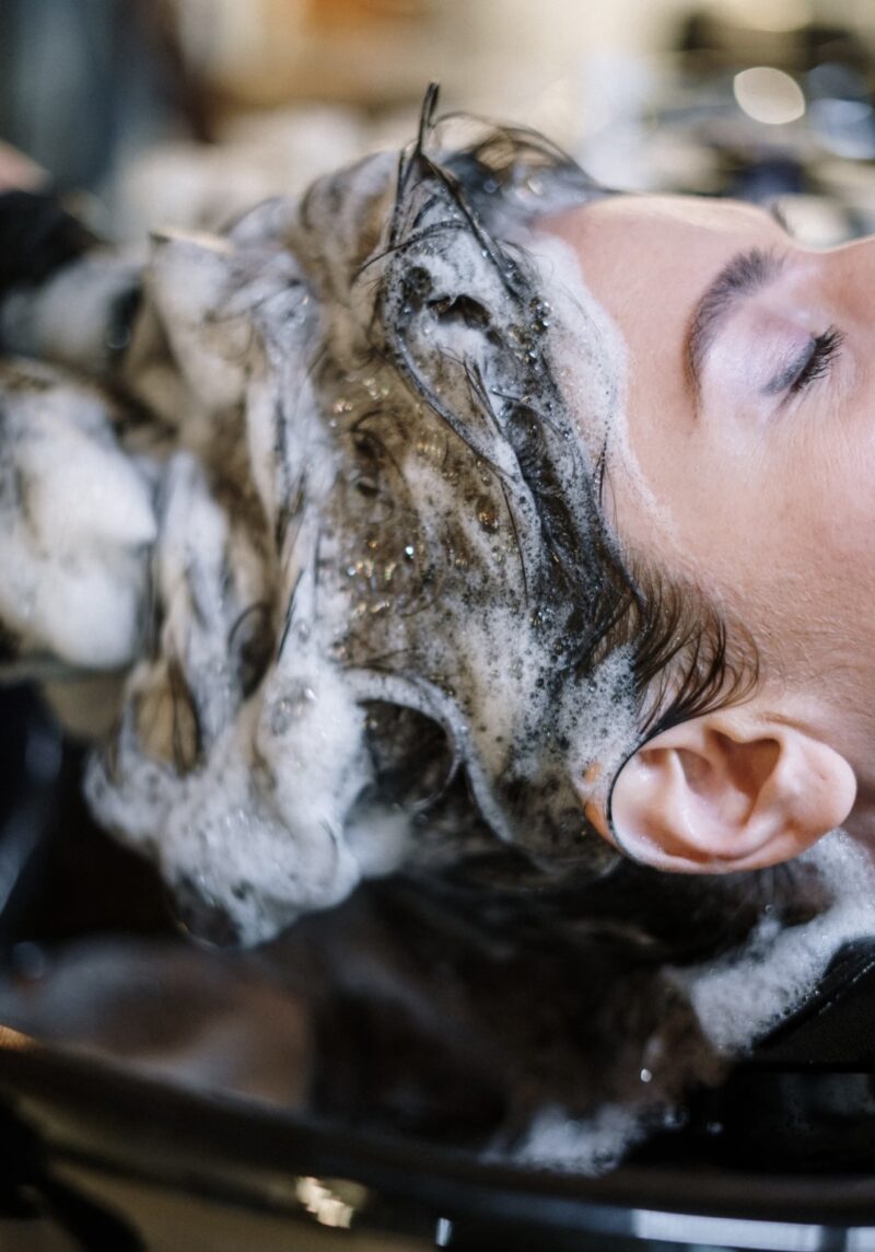 A relaxing hair shampoo treatment at a salon, with foamy lather covering the hair