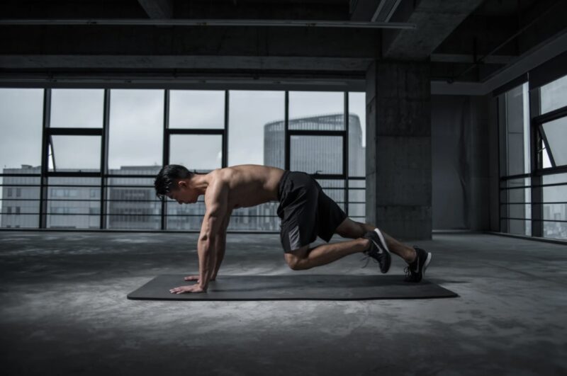 A man doing mountain climbers in a gym, training his upper body strength.